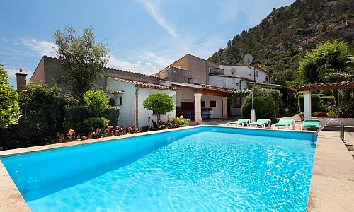 Finca mit Pool und Liegen vor einem Berg