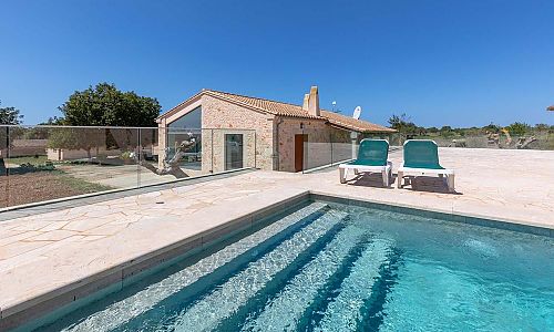 Poolbereich mit Sonnenliegen vor der Finca