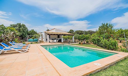 Außenbereich mit Pool Rasenfläche und Sonnenliegen