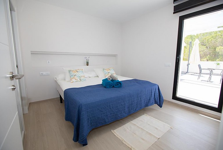 Schlafzimmer mit Doppelbett und Zugang zur Terrasse 