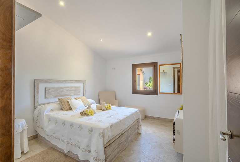 Schlafzimmer mit Doppelbett und Sessel