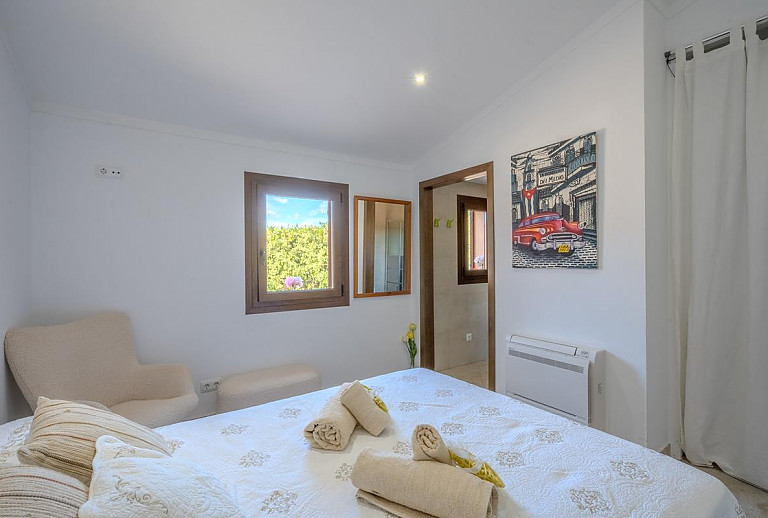 Schlafzimmer mit Doppelbett und Badezimmer