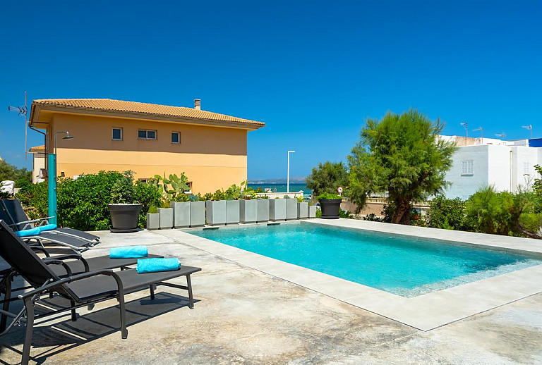 Sonnenliegen am Pool mit Meerblick