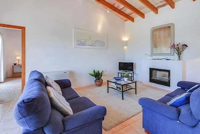Wohnzimmer mit Fernseher und Kamin