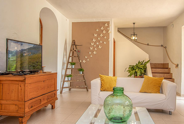 Wohnzimmer mit Couch und Treppe ins Obergeschoss