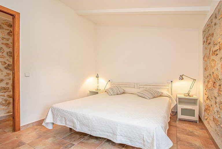 Natursteinwand im Schlafzimmer mit Doppelbett