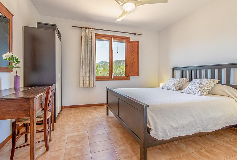 Schlafzimmer mit Doppelbett und Schreibtisch
