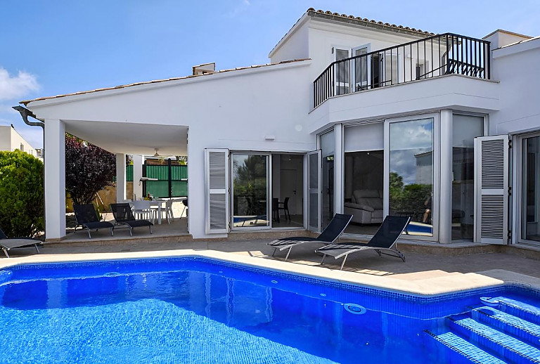 Poolterrasse mit Sonnenliegen vor dem Ferienhaus