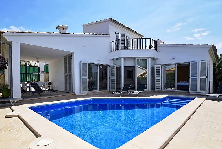 Sonnenliegen auf der Poolterrasse vor dem Ferienhaus