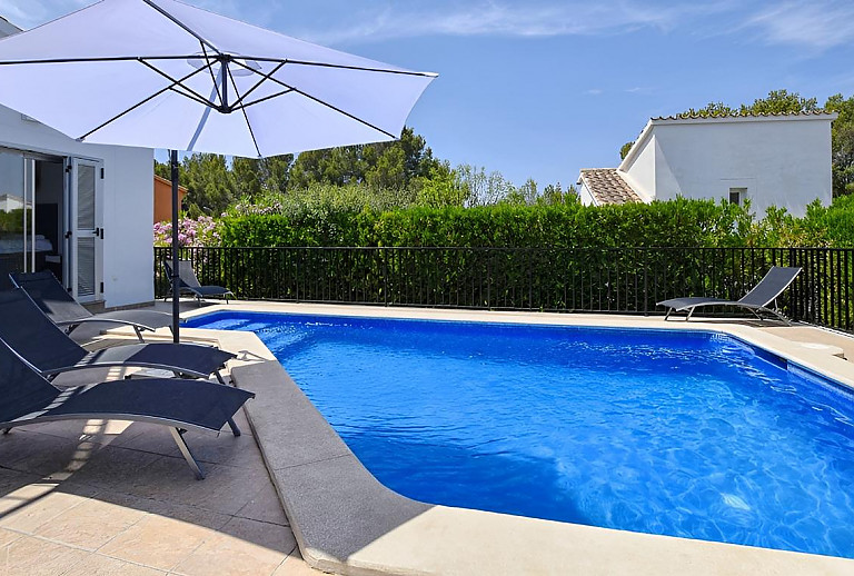 Sonnenschirm und Poolliegen auf der Terrasse