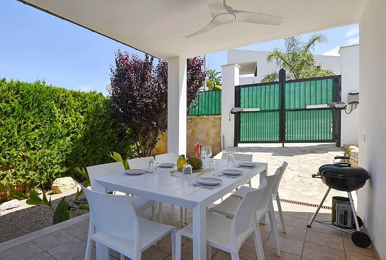 Terrasse mit Esstisch und Hecke
