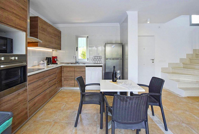 Küche mit Esstisch und Kühlschrank