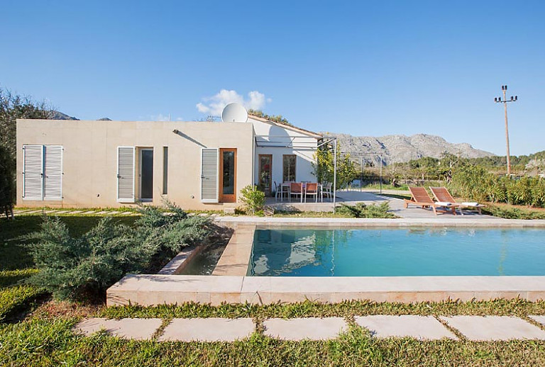 Gartenbereich Pool Sonnenliegen Terrasse Tisch Stuehle Bergblick