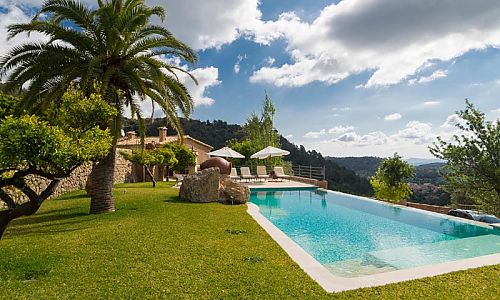 Gartenbereich Pool Rasenflaechen Palmen Ausblick Sonnenliegen Sonnenschirme Terrasse