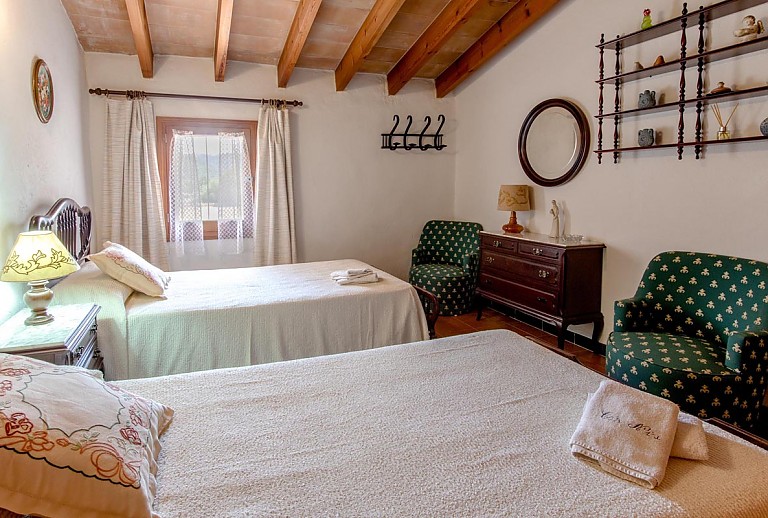 Schlafzimmer mit Betten Wandregal und Kommode