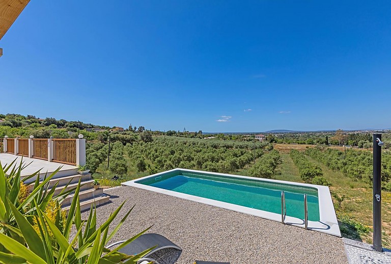 Blick von der Terrasse auf den Pool und die Landschaft