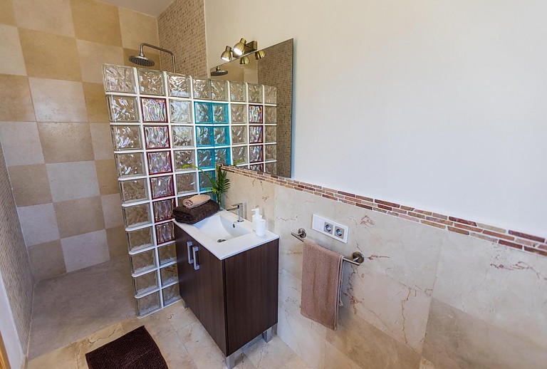 Dusche im Badezimmer mit Waschbecken und Spiegel