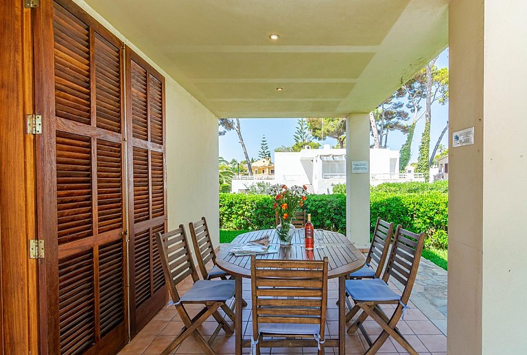 Terrasse mit Esstisch und Stühlen im Schatten