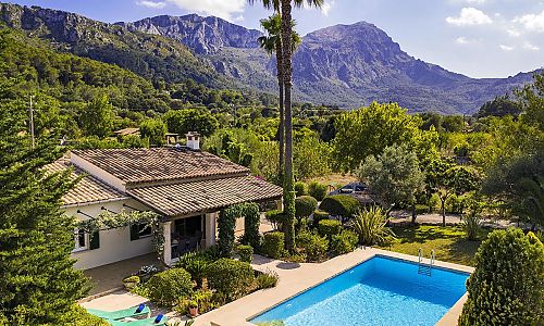 Poolbreich vor der Finca mit Sonnenliegen Pflanzen und Bäumen