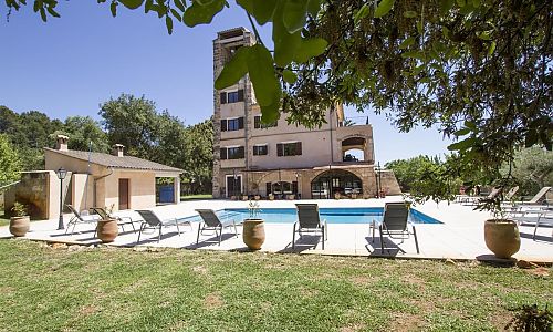 Außenbereich mit Pool Rasen und Bäumen vor der Finca