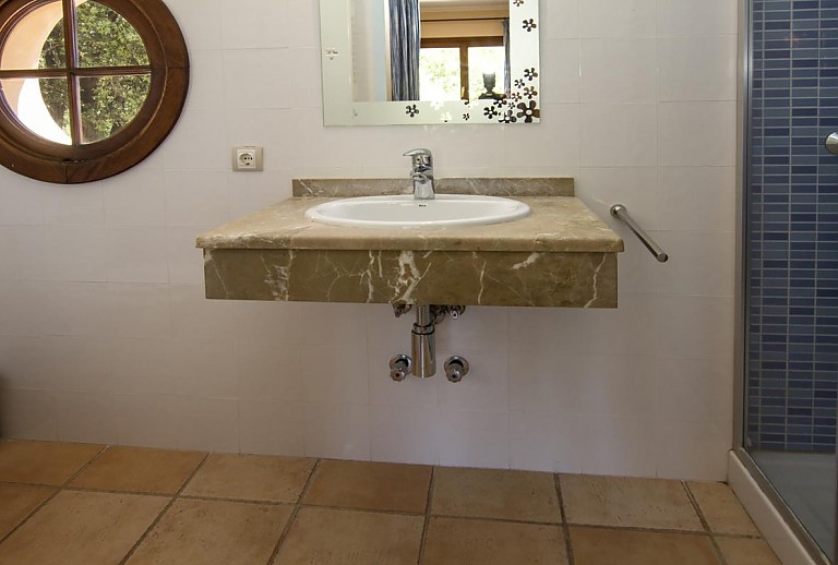 Badezimmer mit Dusche und Waschbecken und Fenster