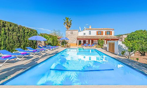 Pool mit Sonnenliegen und Hecke vor der Finca