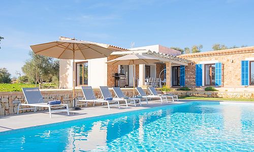 Poolbereich mit Sonnenliegen und Sonnenschirm vor der Finca