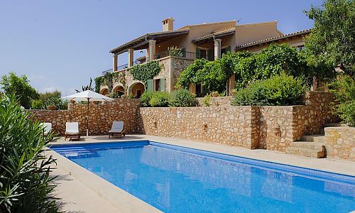 Poolbereich mit Sonnenliegen vor der Finca