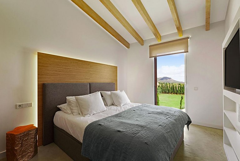 Schlafzimmer mit Doppelbett und Fernseher