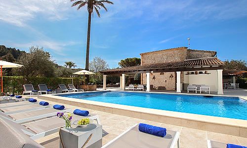 Außenbereich mit Pool und Sonnenliegen vor der Finca