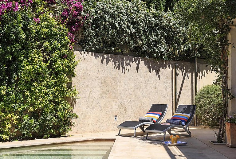 Sonnenliegen am Pool mit Hecke