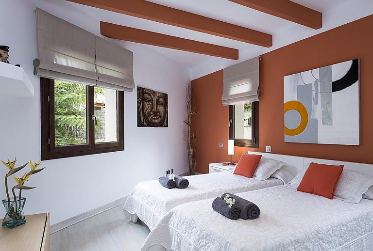 Schlafzimmer mit Einzelbetten und Wandbild