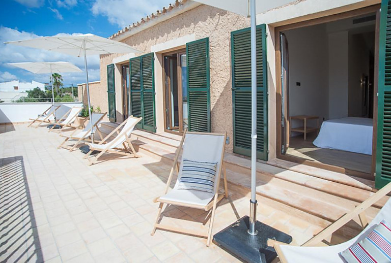 Liegestühle auf der Terrasse mit Sonnenschirm