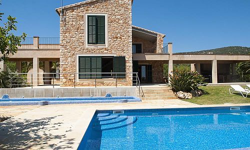 Pool mit Sonnenliegen vor dem Ferienhaus