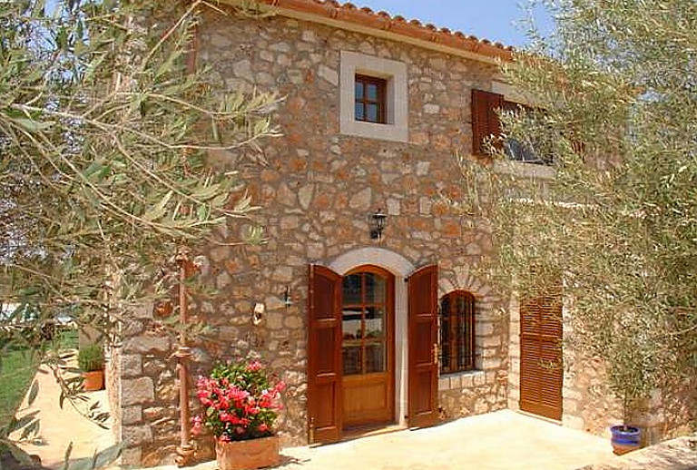 Natursteinfinca mit Topfpflanzen und Eingangsbereich