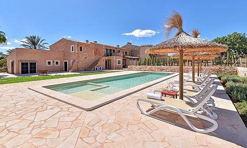 Sonnenschirm und Poolliegen am Pool