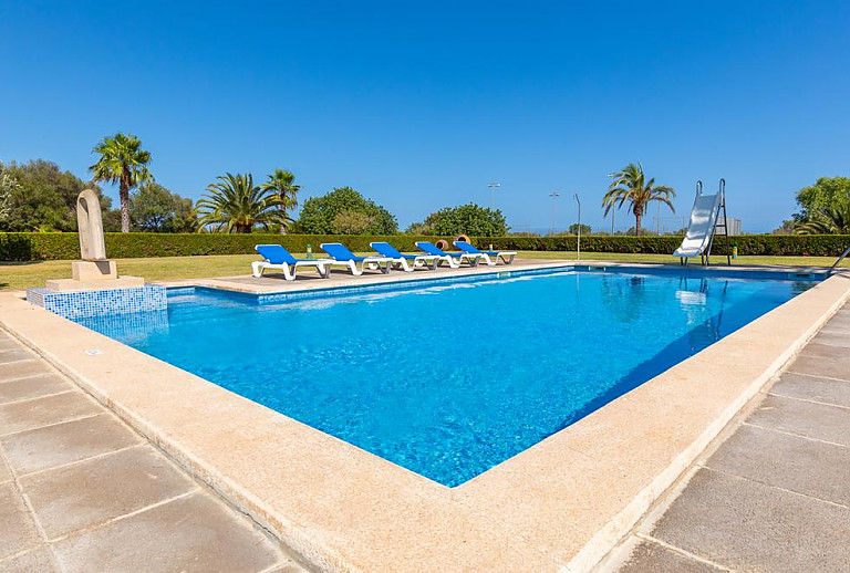 Pool mit Sonnenliegen vor dem Ferienhaus