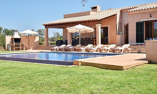 Pool mit Sonnenliegen vor dem Ferienhaus