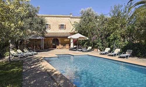 Pool mit Sonnenliegen vor der Finca