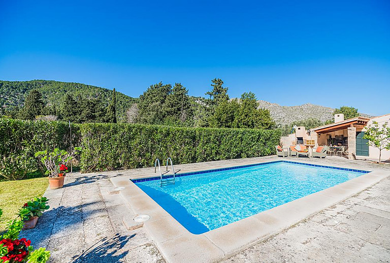 Pool mit Sonnenliegen und Bergblick