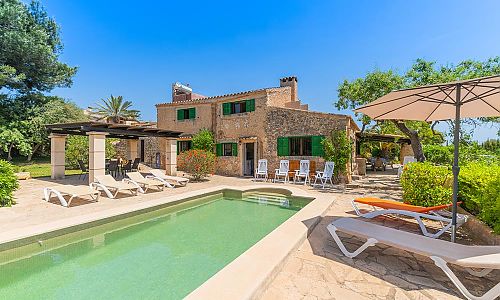 Pool mit Sonnenliegen vor der Natursteinfinca