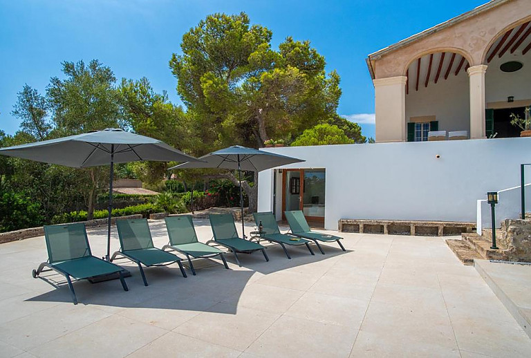 Terrasse mit Sonnenliegen vor dem Ferienhaus