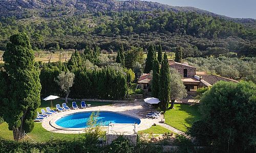 Pool mit Sonnenliegen und Rasen vor der Finca