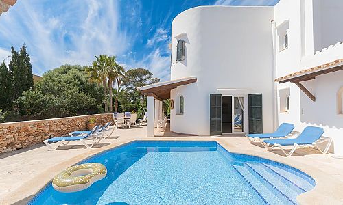 Poolbereich mit Sonnenliegen vor dem Ferienhaus