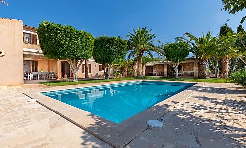 Garten mit Pool und Sonnenliegen vor der Finca