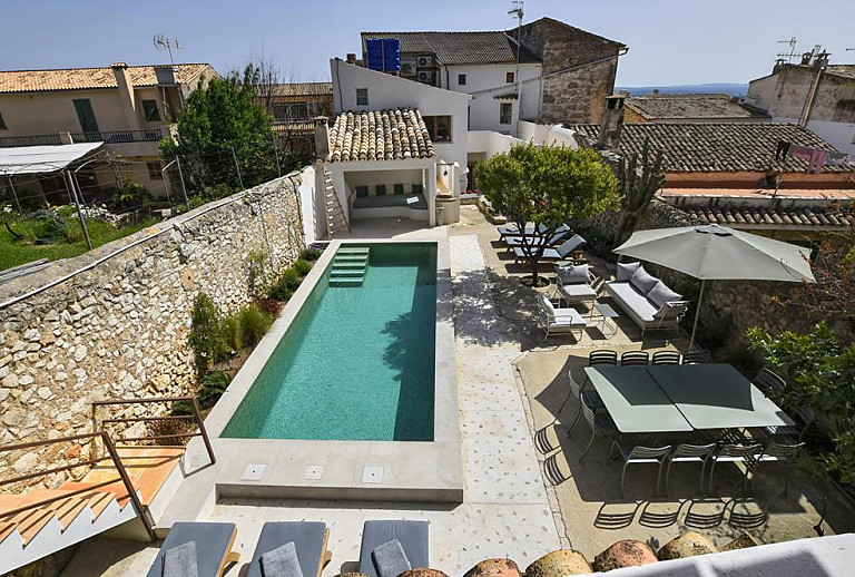 Außenbereich mit Pool und Sonnenschirm