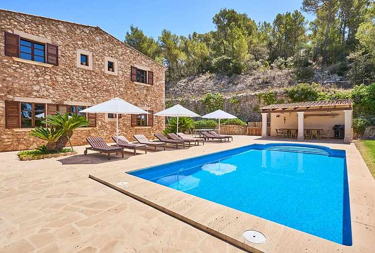 Poolterrasse mit Sonnenliegen vor der Finca