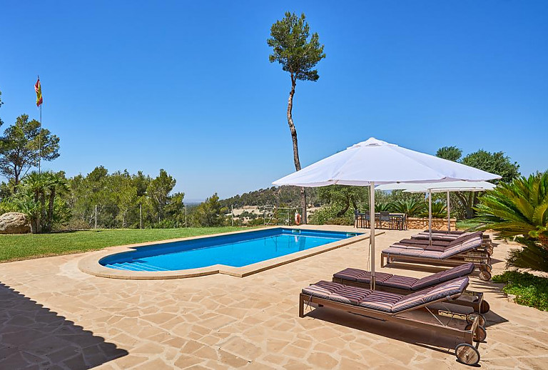 Sonnenschirm und Sonnenliegen am Pool
