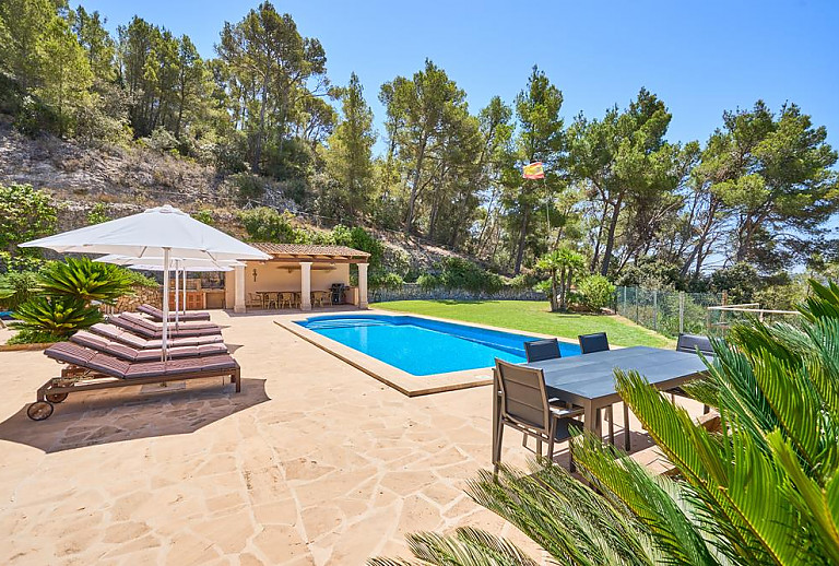 Poolterrasse mit Esstisch und Sonnenliegen