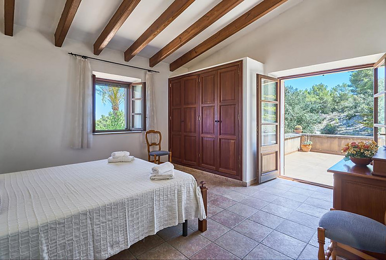 Schlafzimmer mit Einzelbett und Terrassentür